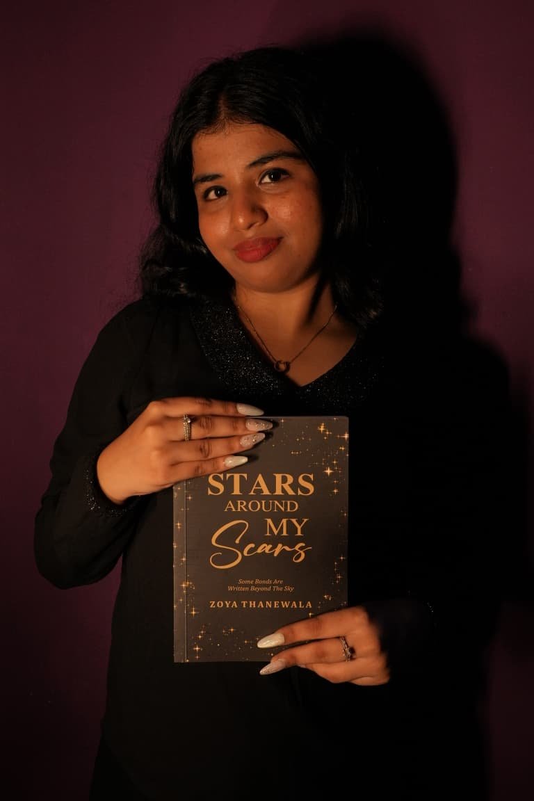 Author Zoya Thanewala holding her debut novel Stars Around My Scars
